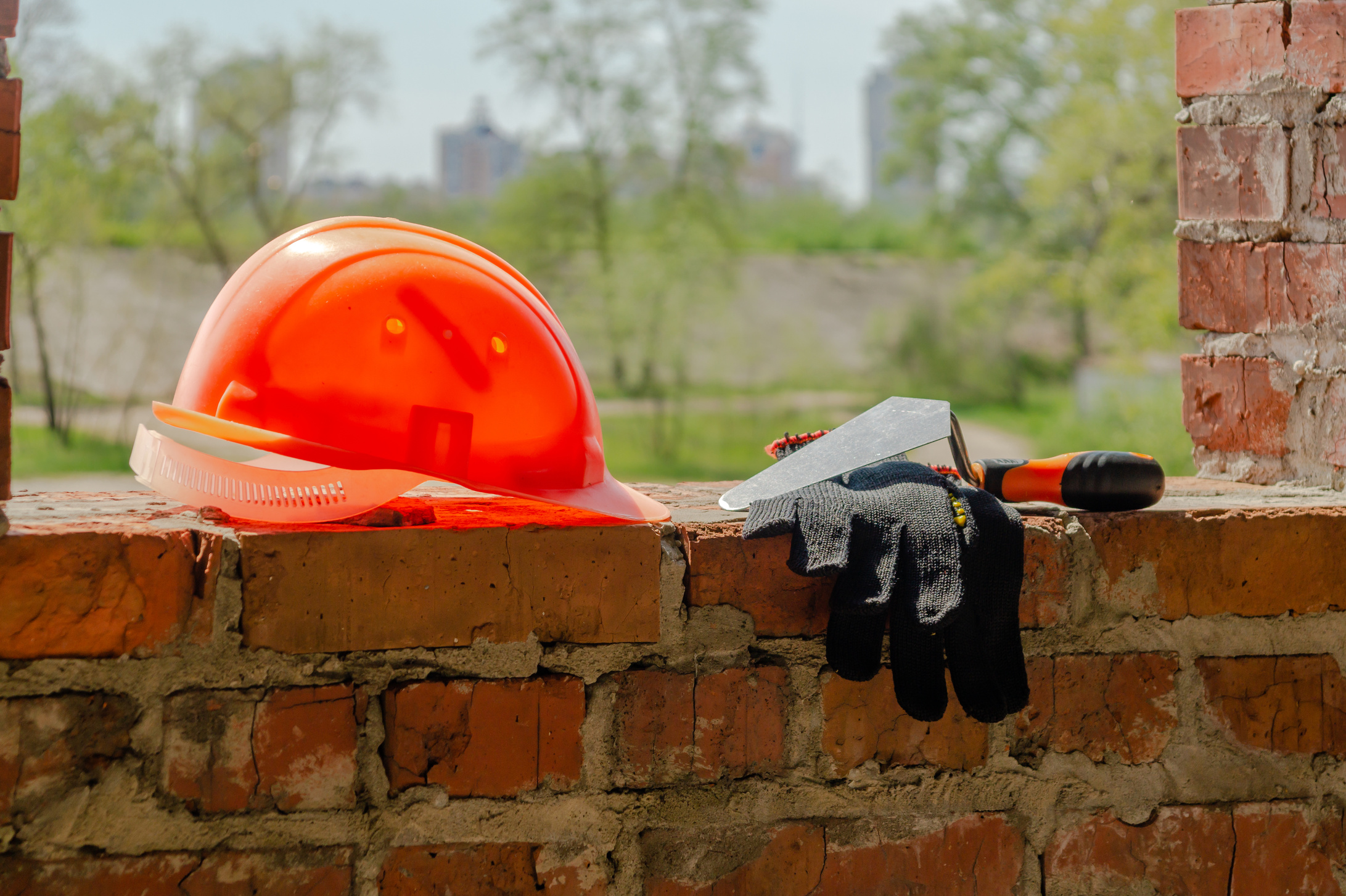 A pair of gloves and a Mason's helmet at the construction.